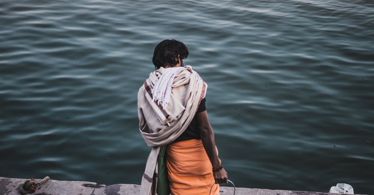 What scenes are missable and how can I make sure to not miss them? - Back view of anonymous ethnic male with metal can standing on wet concrete embankment near rippling sea in coastal area