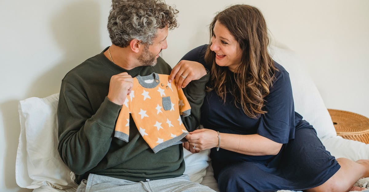 What should I consider when choosing which monsters to keep? - Cheerful pregnant couple resting on bed while preparing clothes for infant and looking at each other What should I consider when choosing which monsters to keep? - Cheerful pregnant couple resting on bed while preparing clothes for infant and looking at each other
