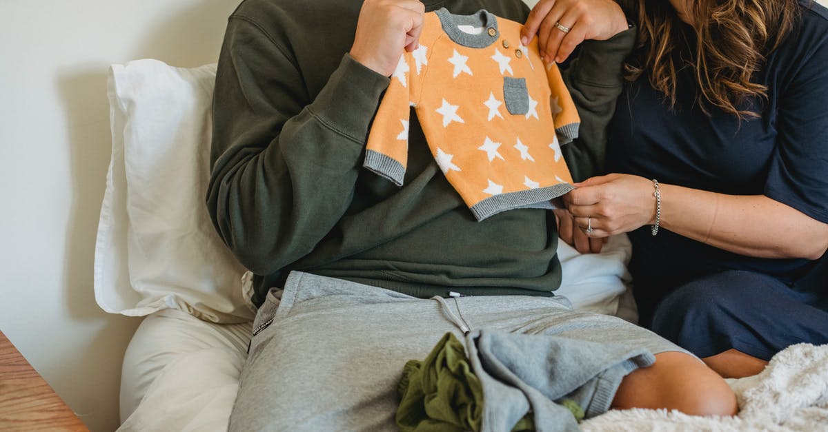 What should I consider when choosing which monsters to keep? - Crop faceless couple considering new apparel for newborn baby while resting on soft bed What should I consider when choosing which monsters to keep? - Crop faceless couple considering new apparel for newborn baby while resting on soft bed