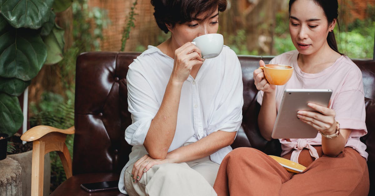 What special markup options are there in Discussions and how to use them? - Thoughtful Asian women in casual clothes drinking cups of beverage and looking at screen of tablet What special markup options are there in Discussions and how to use them? - Thoughtful Asian women in casual clothes drinking cups of beverage and looking at screen of tablet