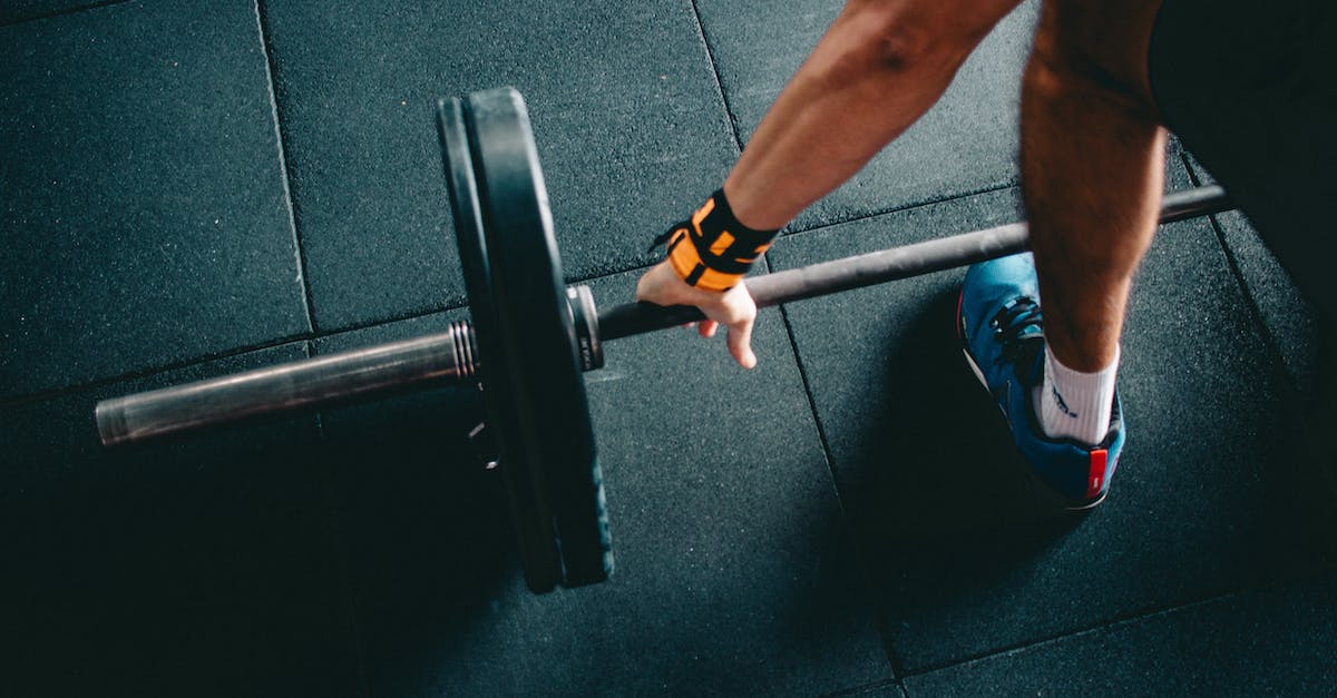 What stats do I need to boost when wearing heavy armor? - Person Wearing Black Shorts and Blue Lace-up Low-top Sneaker Holding Black Barbell