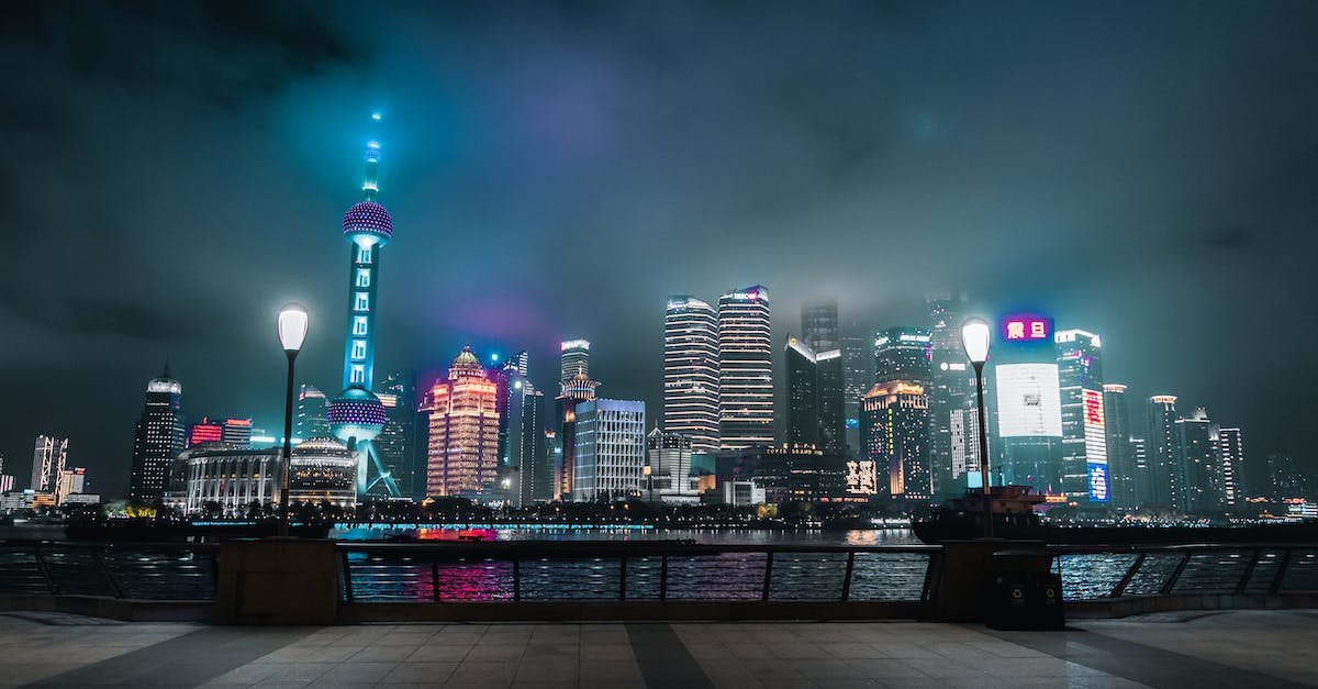 What stops underleveled players from 'leeching' in high torment levels? - Modern skyscrapers illuminated by street lights under sky in evening