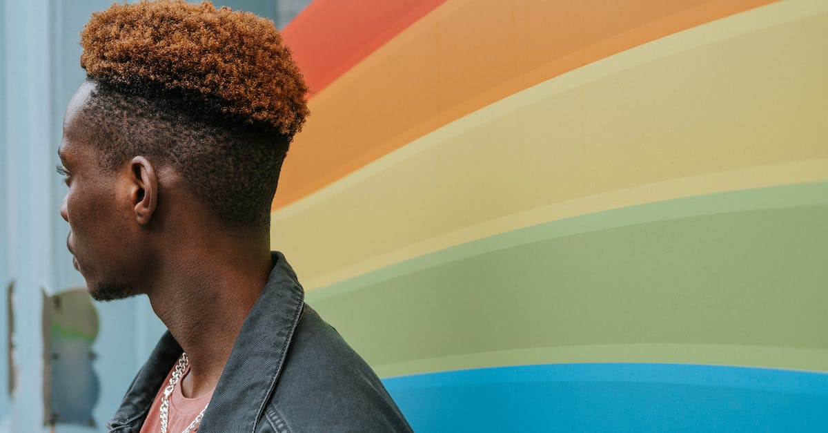 What tick is right before 0? [duplicate] - Side view of young black male millennial with trendy haircut in casual outfit standing near wall with LGBT flag and looking away