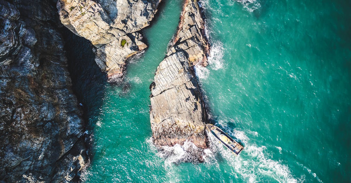What to do if you misplace your ship - Aerial View of Watercraft Beside the Brown Rock Formation