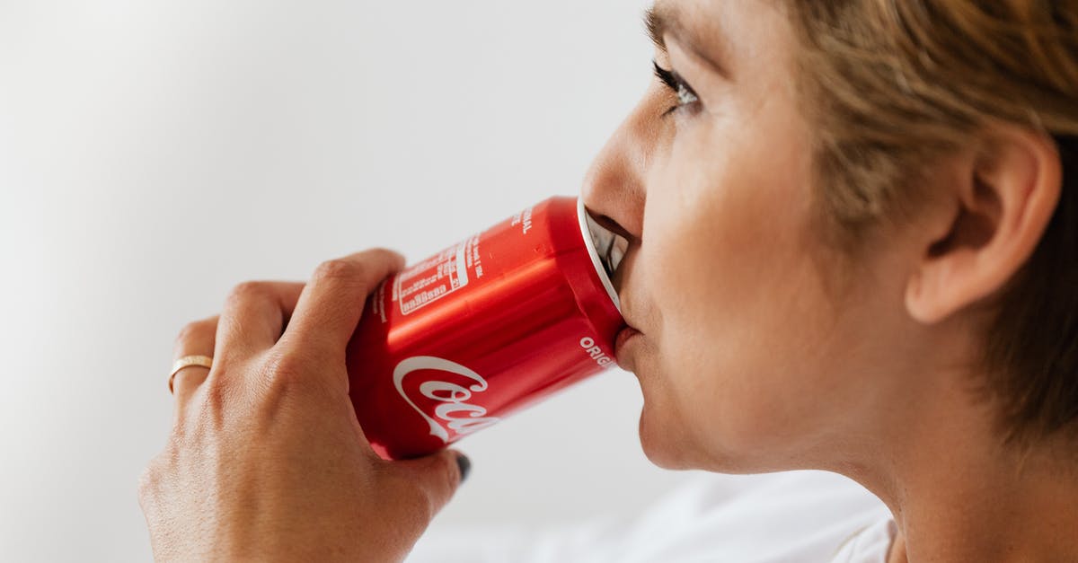 What trophies can be viewed on each PlayStation platform? - Side view of crop wistful female in casual wear and gold ring enjoying coke from red can while sitting near white wall and looking away