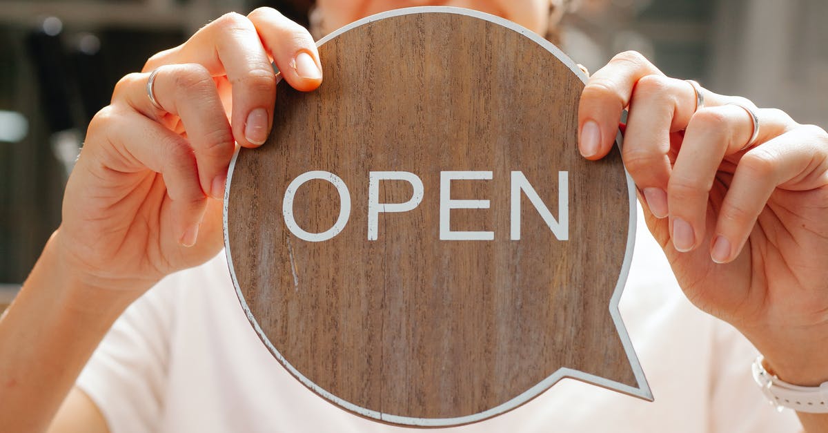What type of buildings offer what level of jobs? - Happy woman showing wooden signboard saying open What type of buildings offer what level of jobs? - Happy woman showing wooden signboard saying open