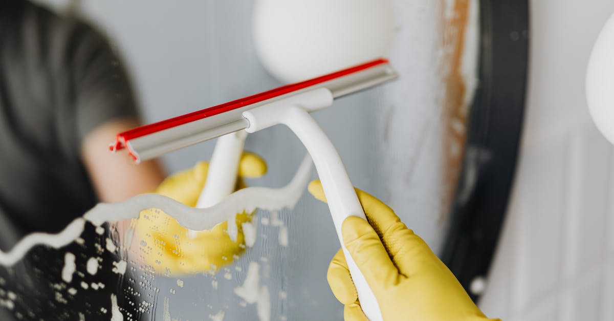 What use is the water pistol? - Anonymous person drying mirror with squeegee What use is the water pistol? - Anonymous person drying mirror with squeegee