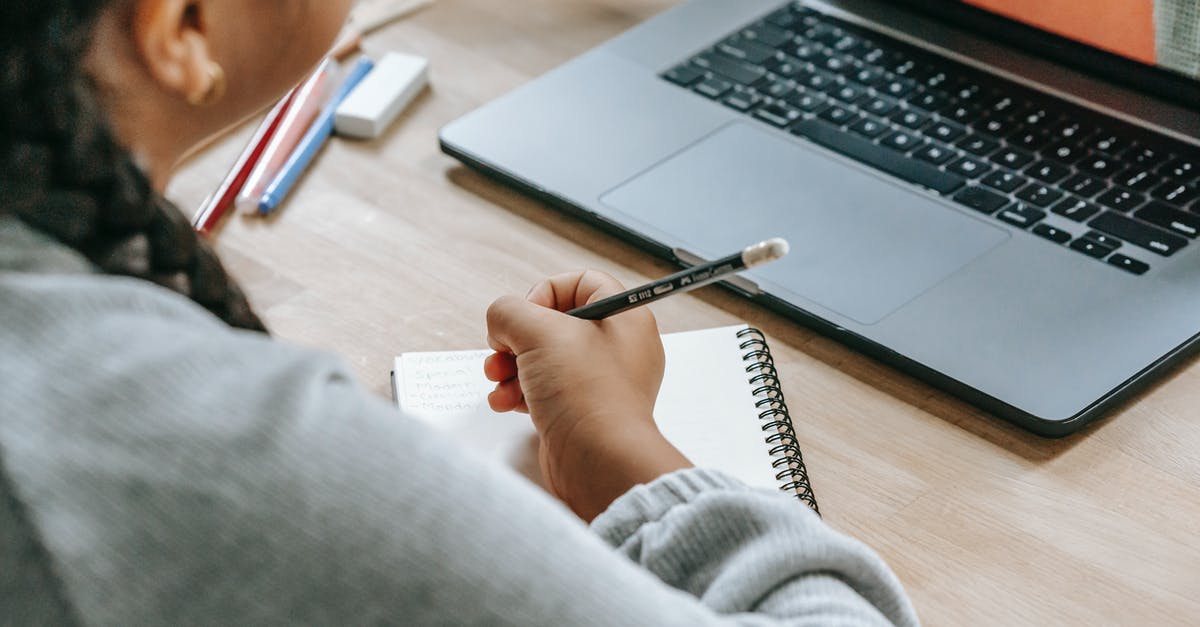 What will Sony do if someone uses my account as primary on another ps4 without my knowledge? - From above of crop anonymous ethnic girl taking notes while watching video through internet