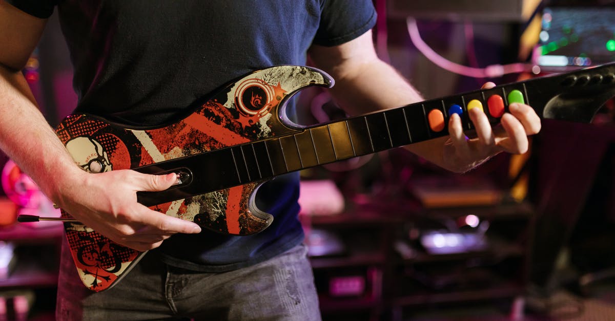 What would be the best character to use playing solo? [closed] - Close-Up View of a Person Playing Guitar Hero