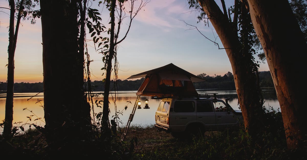 Whats happening to my off shore money? - Picturesque scenery of camping tent placed on SUV car parked on coast of peaceful lake located in woods against amazing sunset sky Whats happening to my off shore money? - Picturesque scenery of camping tent placed on SUV car parked on coast of peaceful lake located in woods against amazing sunset sky