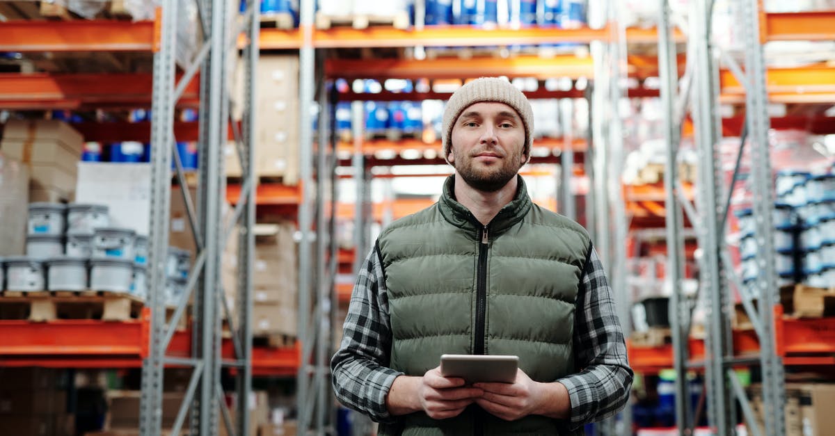 Whats the difference between Depot and Warehouse? - Man in Bubble Jacket Holding Tablet Computer