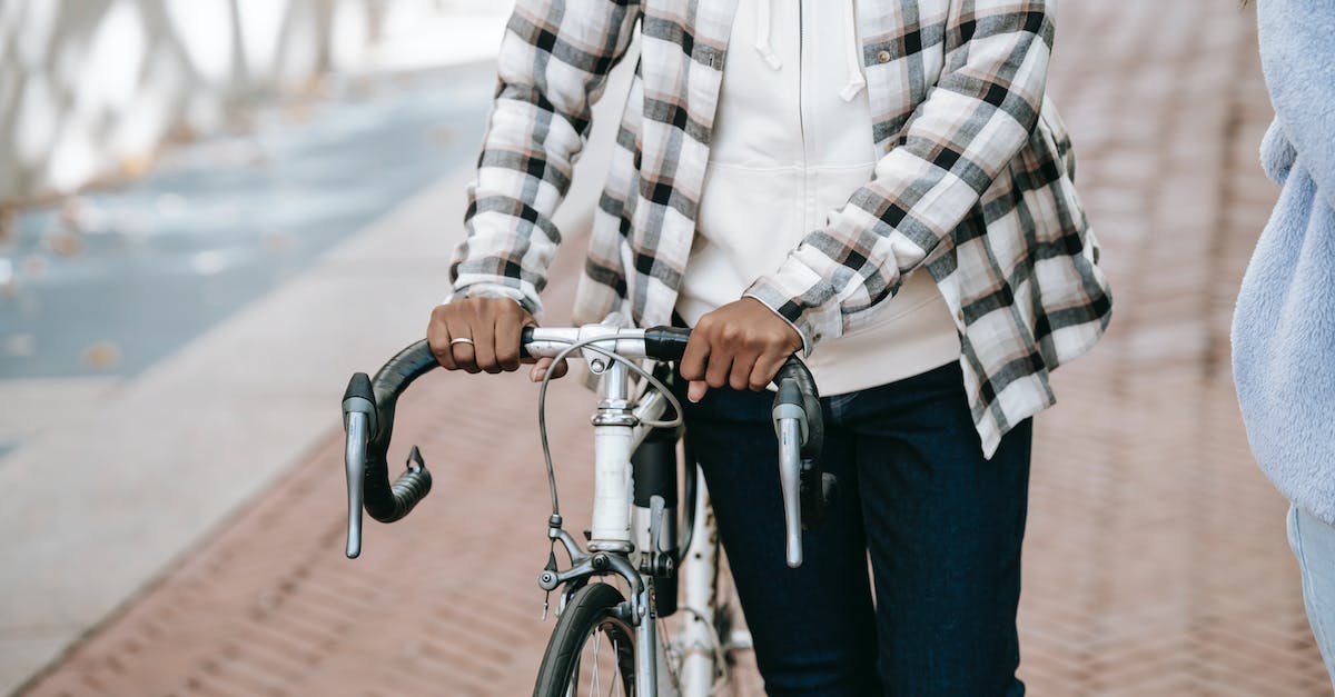 Whats the time cycle for the campsite? - Black woman leading bicycle near friend