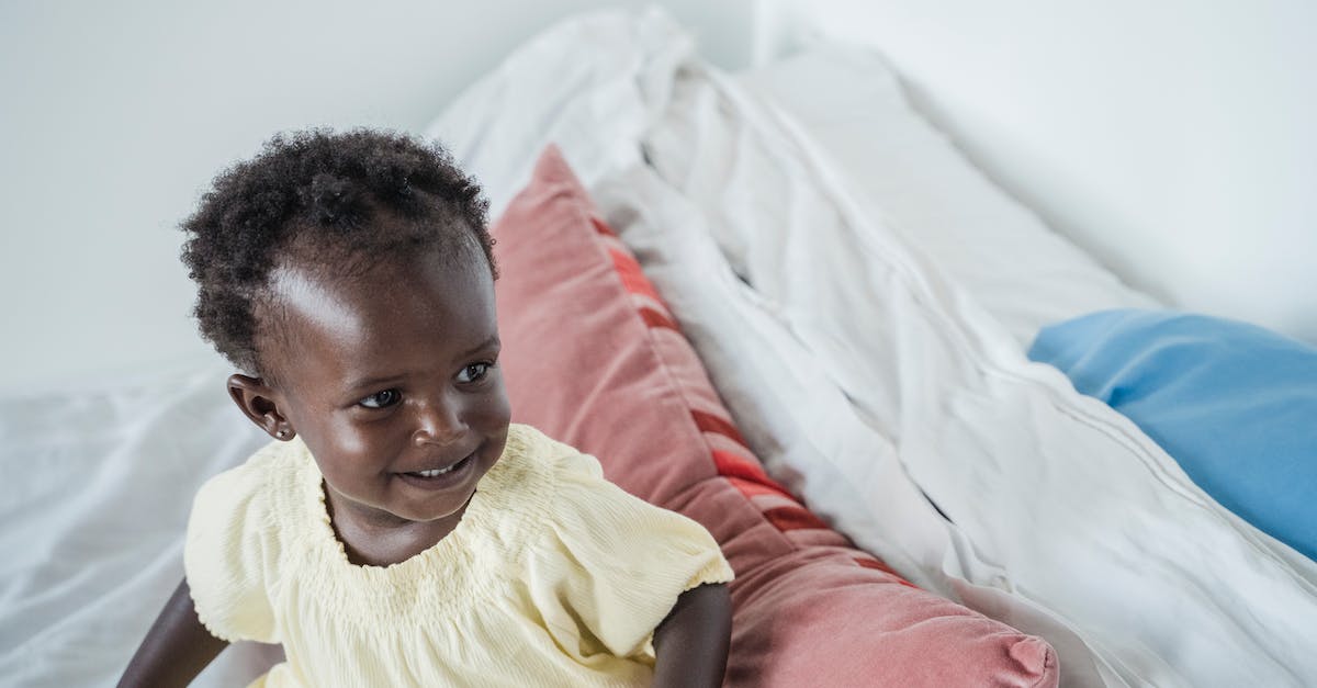 When a baby grows up into a toddler can I change its outfit? - Close-Up Shot of a Baby Sitting on Bed When a baby grows up into a toddler can I change its outfit? - Close-Up Shot of a Baby Sitting on Bed