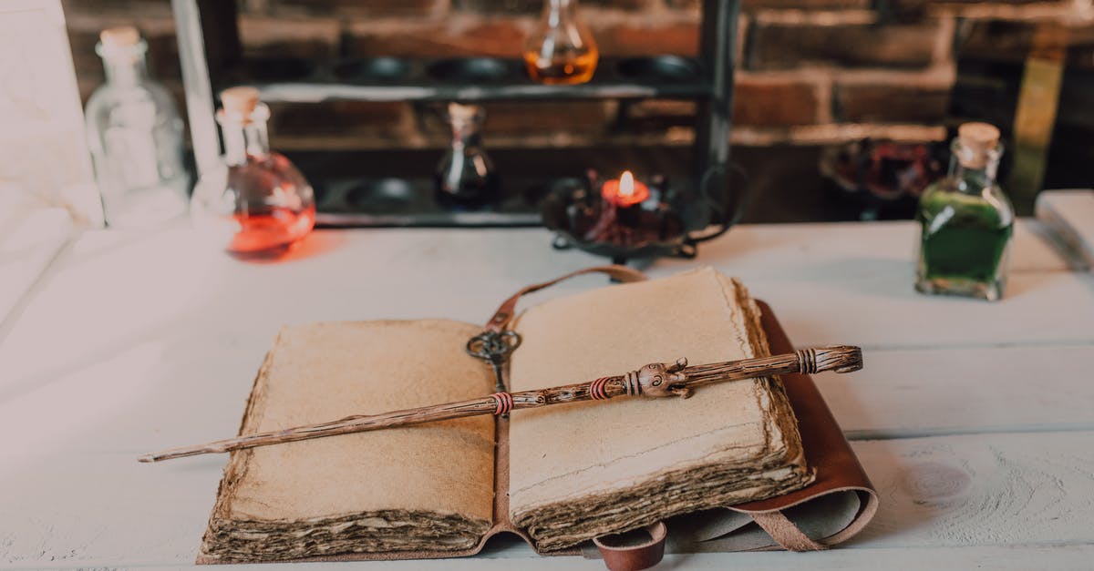 When a wand is broken, does the charge status affect its potency? - Close-Up Shot of a Spell Book and a Wand