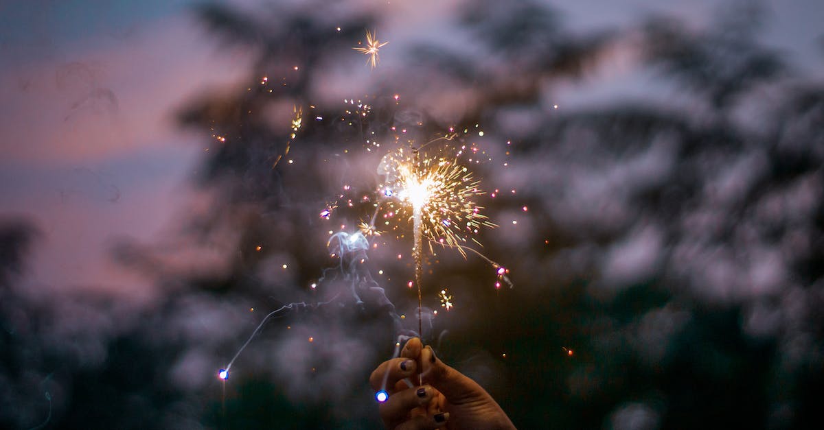 When are mystery parts available for world events? - Crop unrecognizable female holding burning Bengal light near trees in nature against sunset sky When are mystery parts available for world events? - Crop unrecognizable female holding burning Bengal light near trees in nature against sunset sky