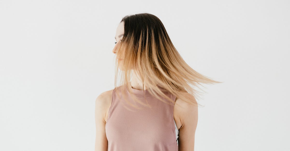 When can a spotted agent safely move into hiding? - Serious unrecognizable young female in casual outfit with long loose hair hiding face standing against white background and looking away