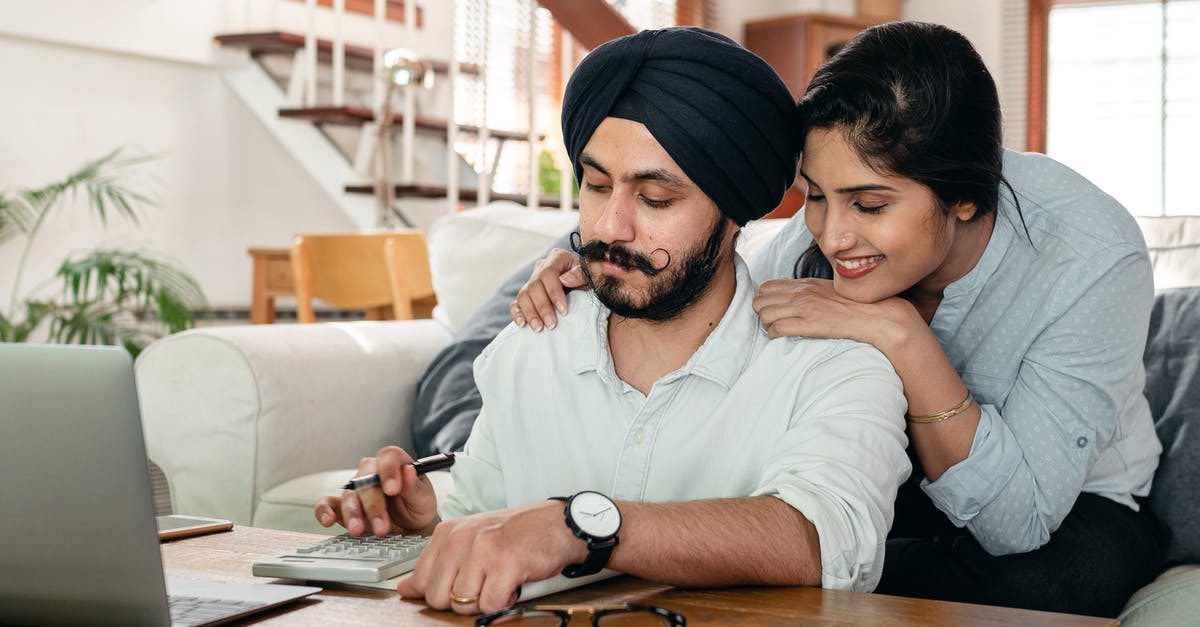 When demanding Vassalization, how is the distance calculated - Cheerful ethnic couple using calculator while sitting at table
