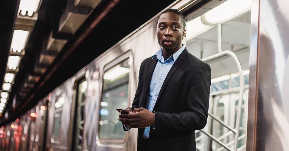 When did monsters get trapped underground in Undertale? - Serious African American man in office wear with mobile phone in hands getting off underground train