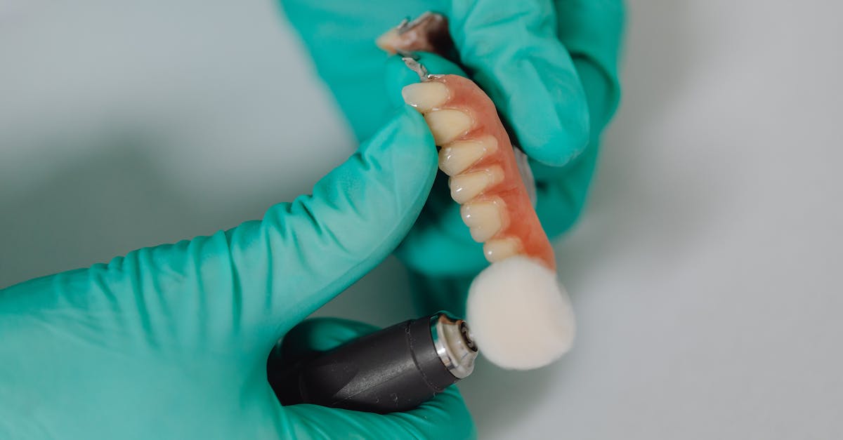 When do implants drop? - Person Hands Polishing Teeth Implants
