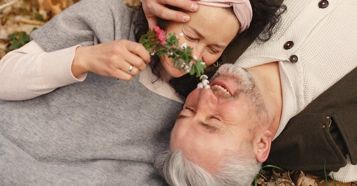 When does the 'Date' occur at Golden Saucer? - From above of cheerful senior wife wearing wide scarf and headband with flower bouquet in hand and happy elderly gray haired husband in warm clothes lying on ground with fallen leaves in park with closed eyes