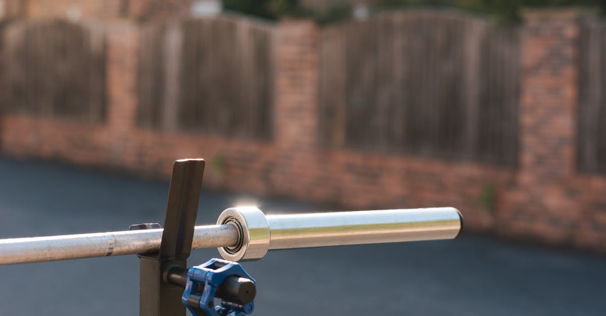 When I activate hard mode, will my world be destroyed? - Part of steel barbell without weight discs for training on stand against fence in sunlight