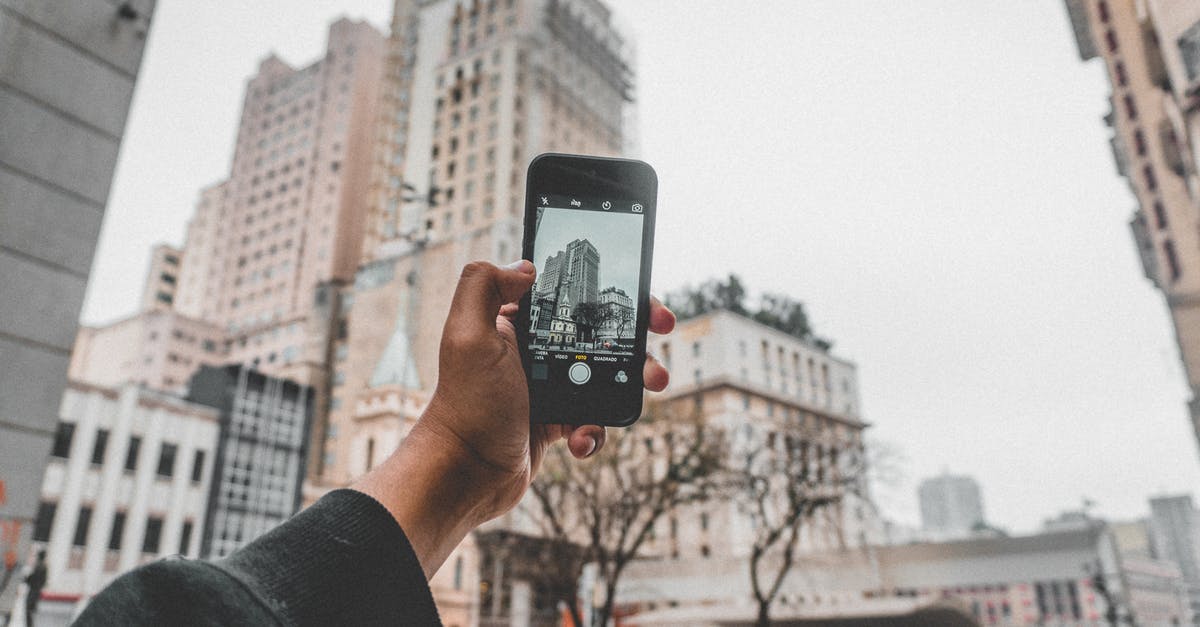 Whenever i use incense to attract pokemon it shows "Failed TO Detect Location"? - Crop anonymous person taking pictures of modern buildings located on urban street by using mobile phone during autumn cold day