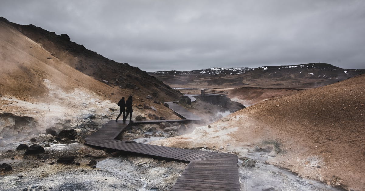 Where are the last survival caches in Geothermal Valley? - Person Standing on Brown Wooden Dock