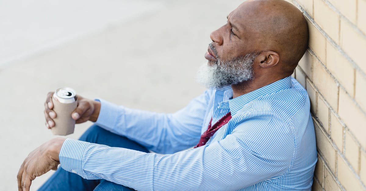 Where can I find a brick? - Depressed black male with beer can leaning on brick wall