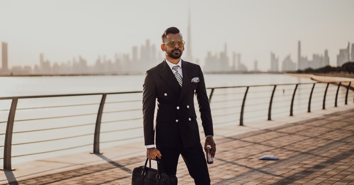 Where can I find a Hooded Cleanroom Suit in Fallout 4? - A Man in Black Suit Holding a Black Briefcase and a Canned Drink