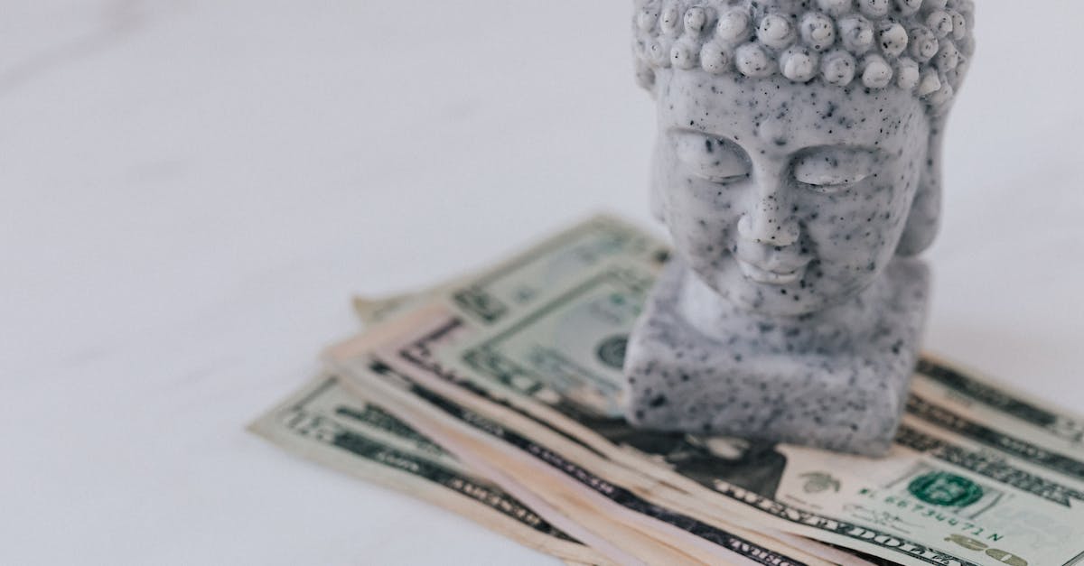 Where can I find an Oval Stone? - Marble decorative bust of Buddha composed on heap of American dollars on white surface