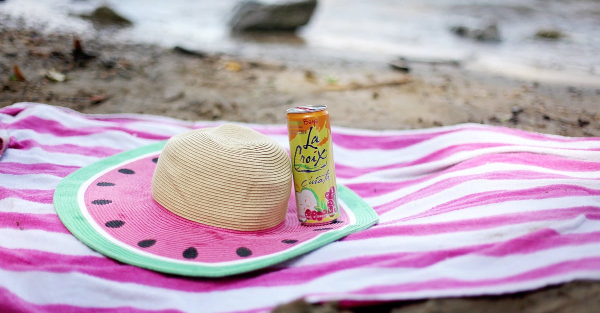 Where can I get pets from? - Striped towel spread on sandy beach with straw hat and juice can