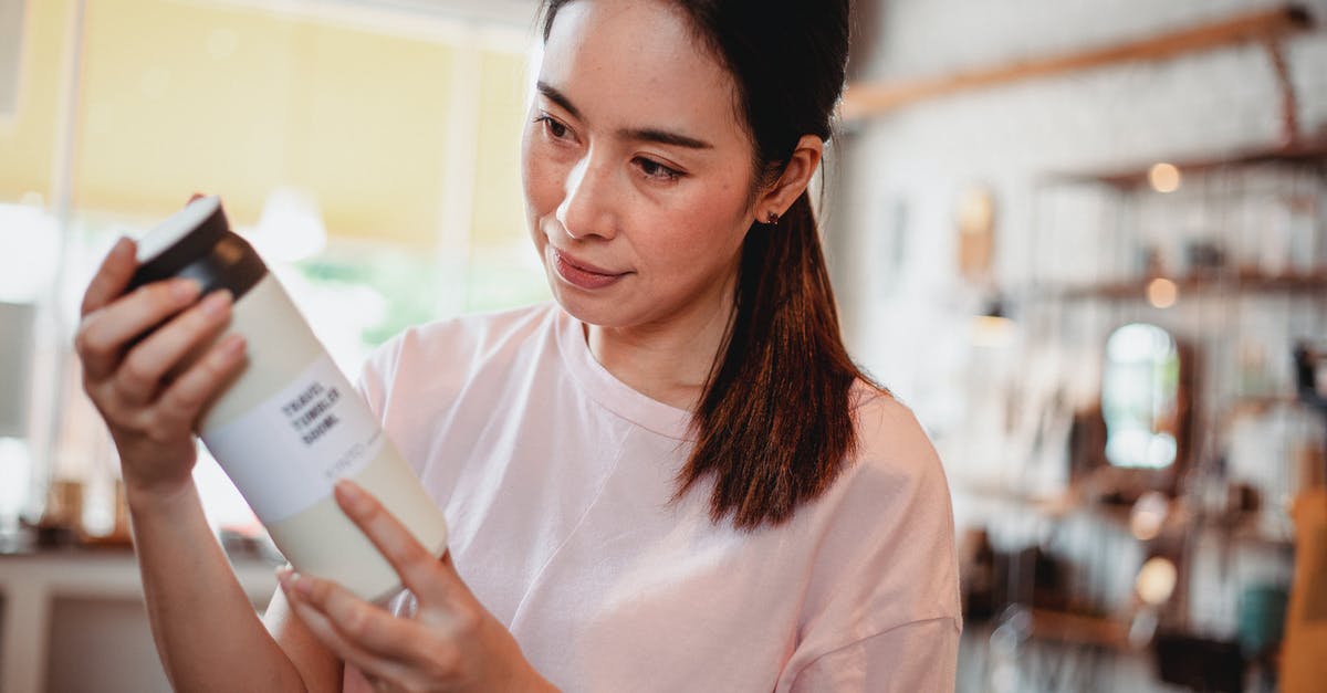 Where can I store my cosmetic gear? - Crop young attentive ethnic shopper reading information on bottle of cosmetic product in store Where can I store my cosmetic gear? - Crop young attentive ethnic shopper reading information on bottle of cosmetic product in store
