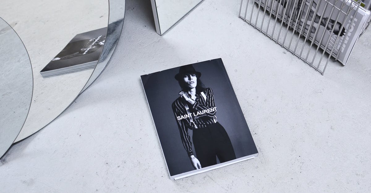 Where did the missing magazines go from my magazine rack? - Black and white high angle fashion magazine placed on table and reflecting in geometrical mirror and rack with journals