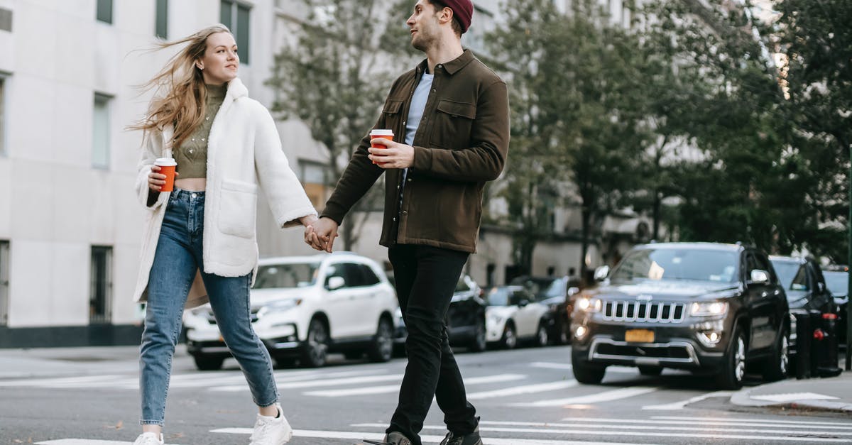 Where did the other races (and genders) go? - Young couple wearing warm jackets and with paper cups of hot drinks crossing road holding hands and looking at each other Where did the other races (and genders) go? - Young couple wearing warm jackets and with paper cups of hot drinks crossing road holding hands and looking at each other