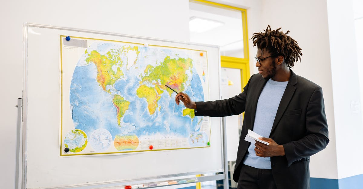 Where did the world go? - Top view of crop anonymous person holding toy airplane on colorful world map drawn on chalkboard Where did the world go? - Top view of crop anonymous person holding toy airplane on colorful world map drawn on chalkboard