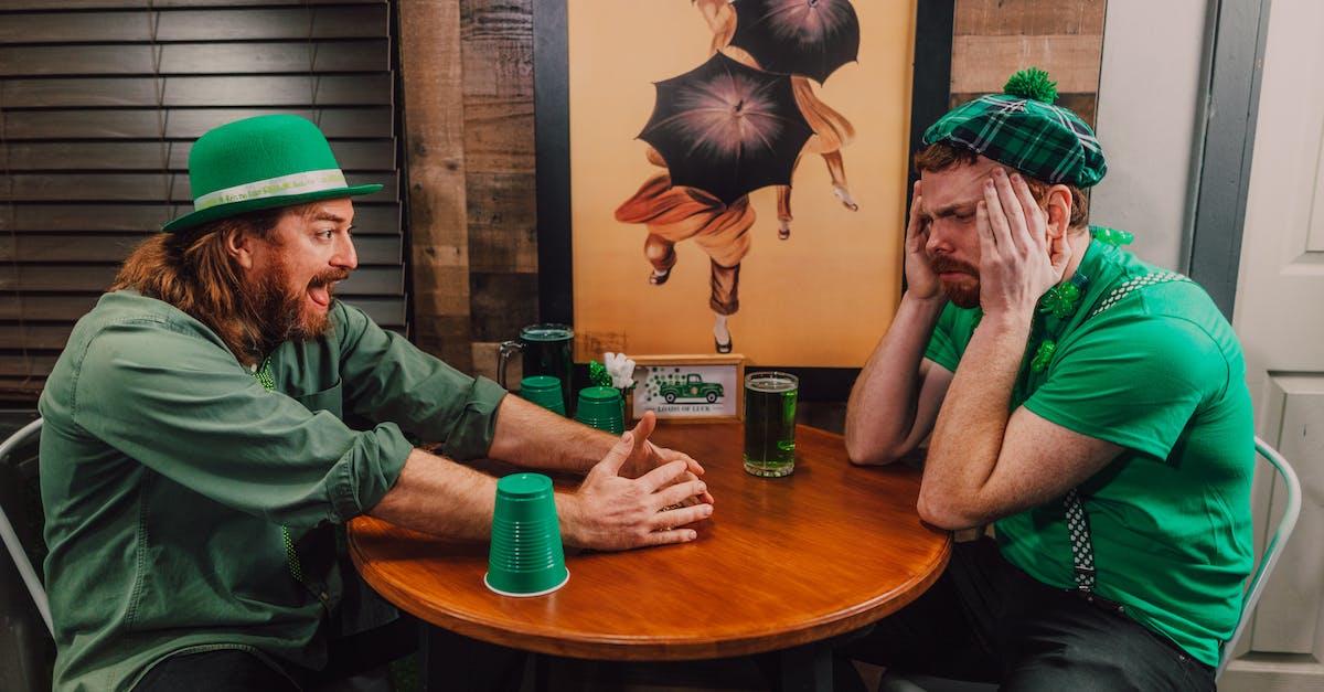Where do I play "The Shell Game"? - Young male friends playing shell game in pub on Saint Patricks Day