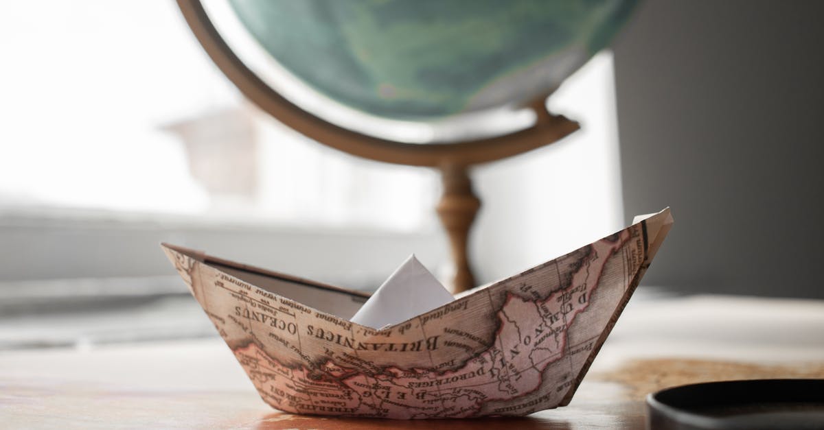 Where does the flat world start to corrupt? - Paper boat near globe in room