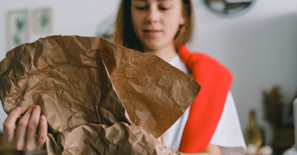 Where does the flat world start to corrupt? - Crop female folding paper while sorting garbage for recycling to reduce pollution of planet