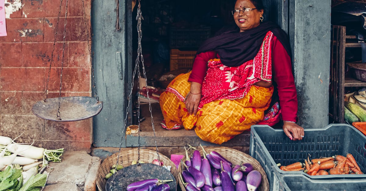 Where is Majni's merchant chest? - Woman in Red and Yellow Sari Sitting on Brown Wooden Chair