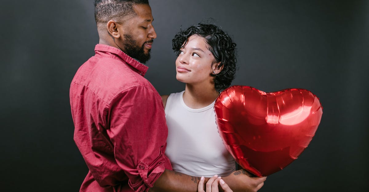 Where is my Happiness? - Couple Looking at Each Other While Holding a Red Heart Shaped Balloon Where is my Happiness? - Couple Looking at Each Other While Holding a Red Heart Shaped Balloon