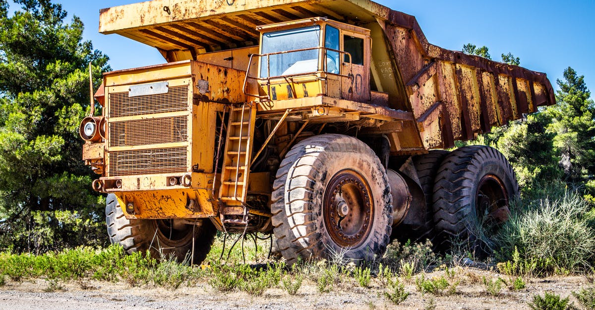Where is "Northwest" in The Dusty Path? - Weathered dump truck on sandy road near green trees in countryside