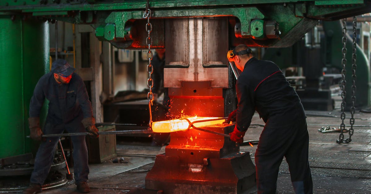 Where is the blacksmith? - Two Men Holding Two Gray Metal Tools Where is the blacksmith? - Two Men Holding Two Gray Metal Tools