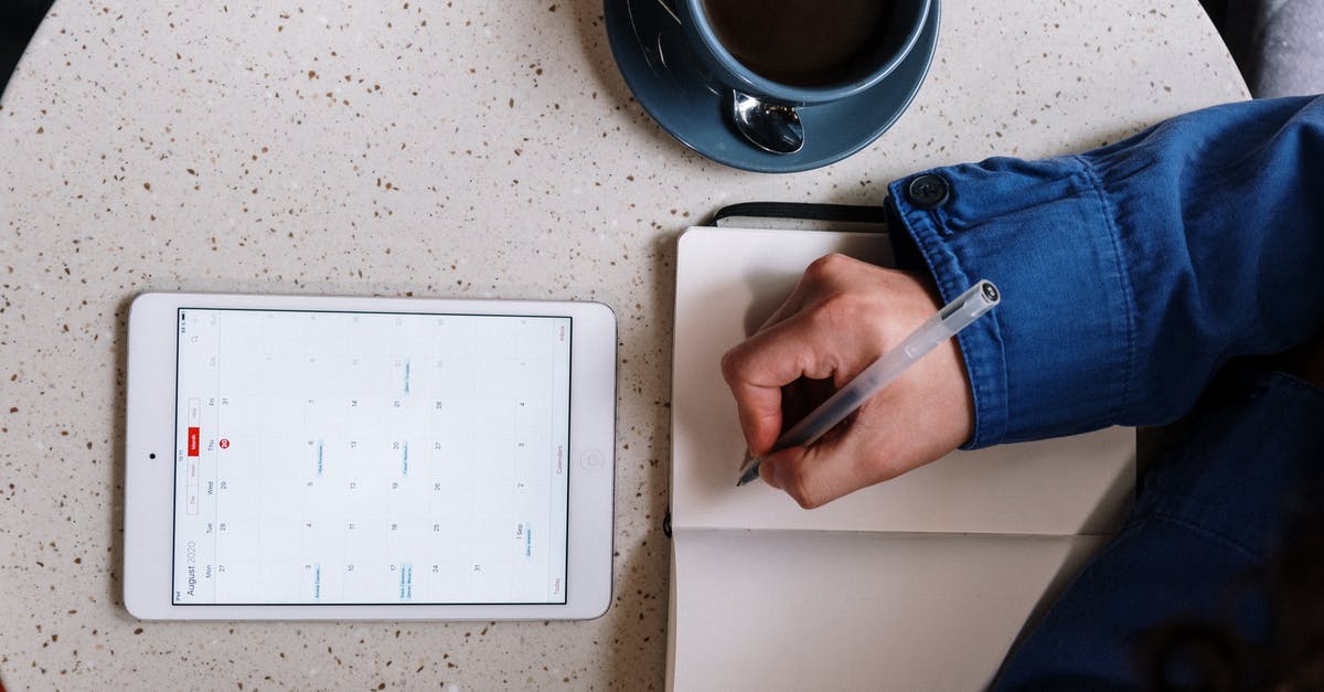 Where is the program scheduler on the iPad version? - Person Holding Pen and Checking Calendar on Tablet