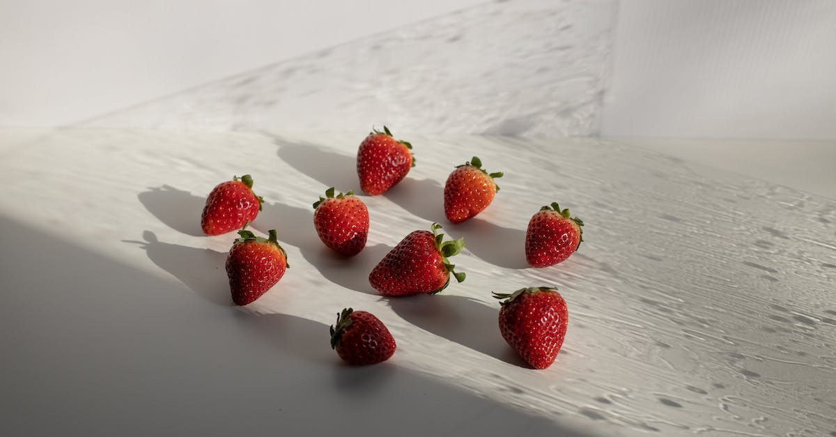 Where is this shadow coming from? - High angle of fresh ripe red strawberries scattered on white table on sunny day Where is this shadow coming from? - High angle of fresh ripe red strawberries scattered on white table on sunny day