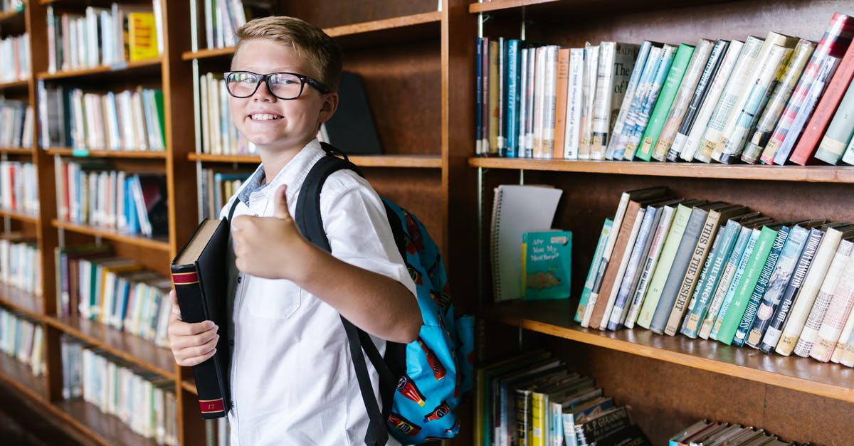 Where should I return all of my overdue library books? - Man in White and Blue Polo Shirt Holding Black Smartphone