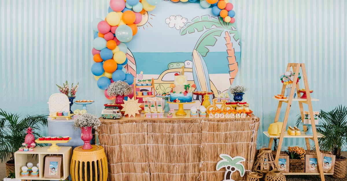 Where should you place candy? - Birthday area with colorful balloons over decorated table with festive cake and presents