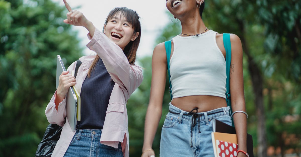Which activities offer the most professor XP per activity point? - Cheerful Asian schoolgirl with laptop and copybooks pointing away while strolling together with smiling African American friend in lush summer park