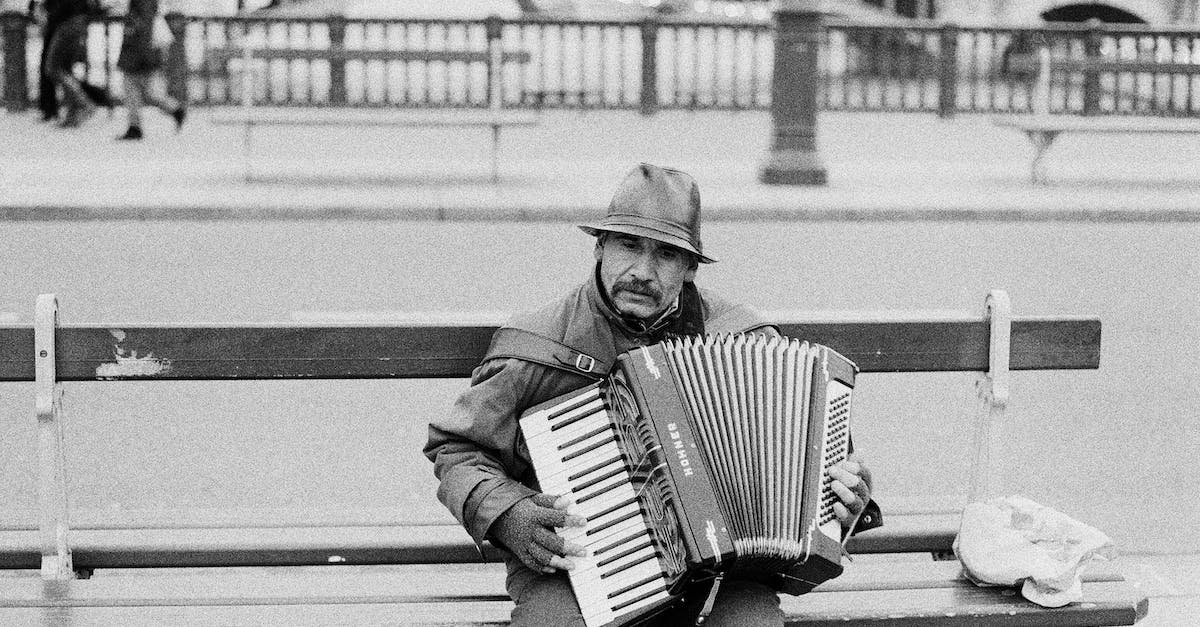 Which cities can I play Pac-Man in? - Man Sitting on a Bench and Playing Accordion Which cities can I play Pac-Man in? - Man Sitting on a Bench and Playing Accordion
