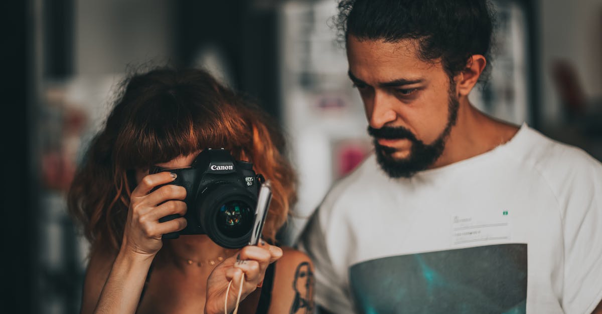 Which crew skills do instant 60s get? - Concentrated female photographer in casual clothes standing near ethnic bearded man and taking pictures on professional photo camera in modern photography school