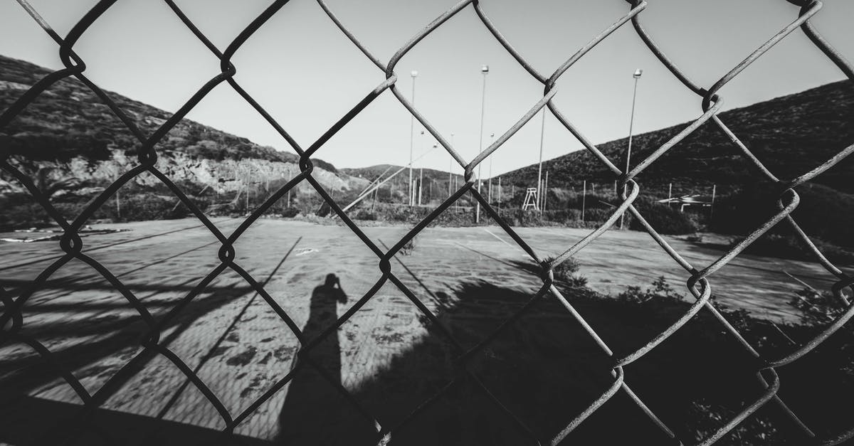 Which game is this Link from? - Through metal net fence of black and white sports ground surrounded by mountains on sunny day
